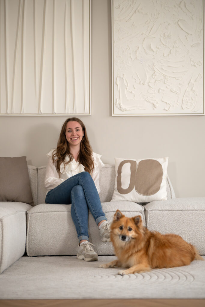 Tamira zit op de bank met haar roodblonde hond ontspannen naast zich